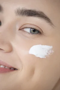 Zbliżenie na twarz z nałożonym kremem pod makijaż